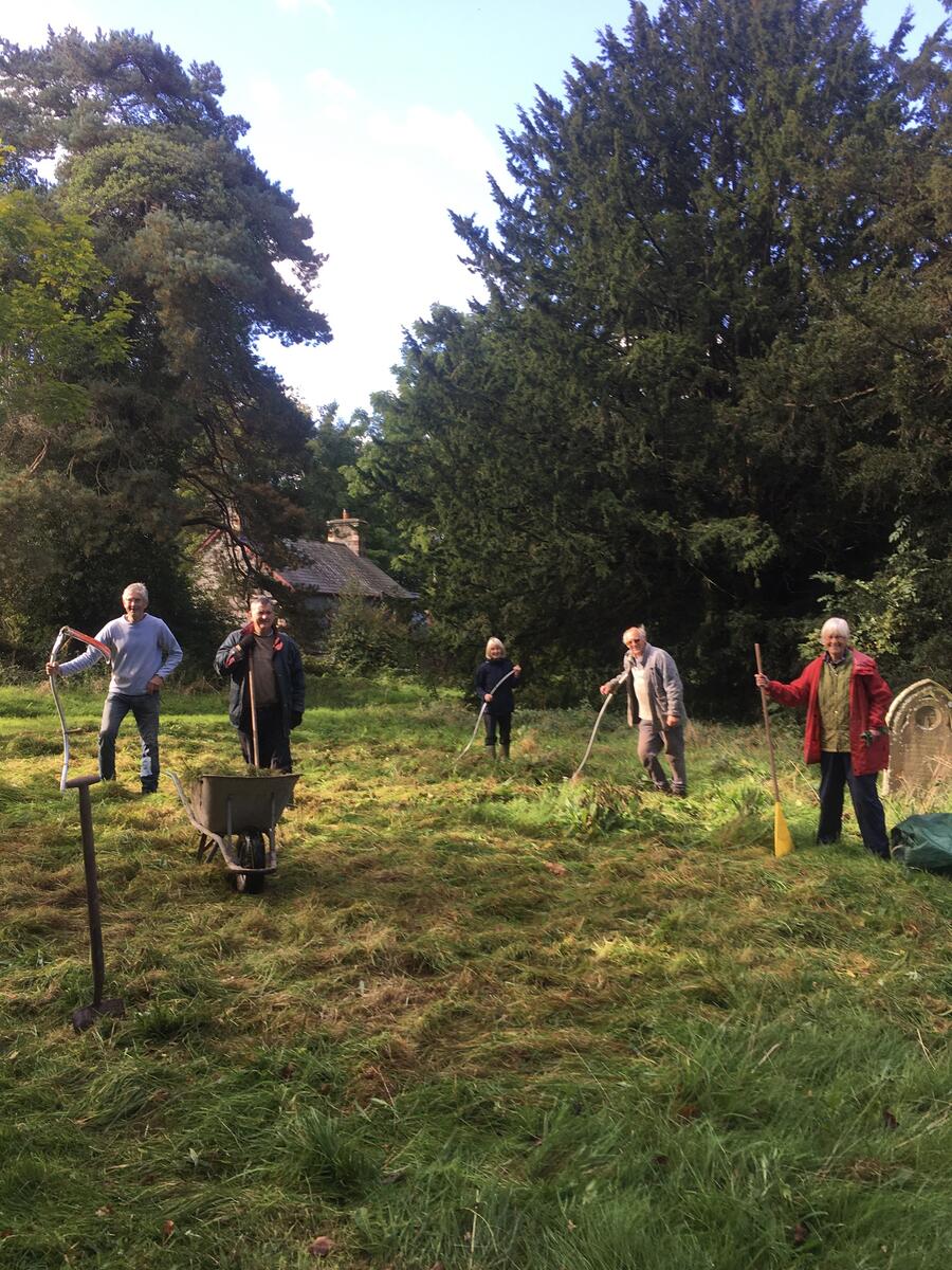 Cutting the meadow in the churchyard with scythes and planting yellow rattle seed.