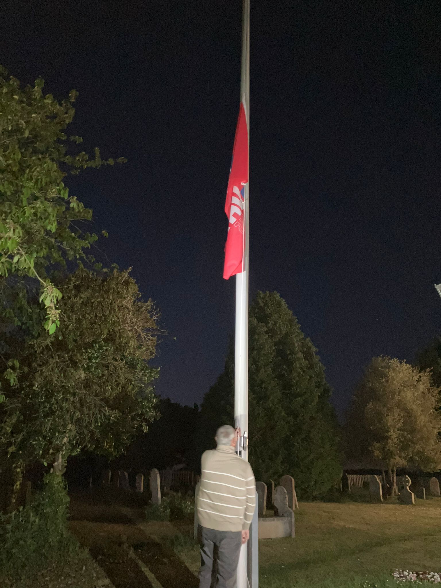 Former serviceman Brian Cooper lowers flag at 10 pm . . .