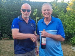 Jonathan the am 18 hole winner gets his prize from a cool dude