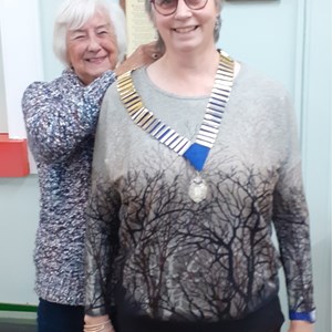 Liz Dyer receiving President chain for 2026 from Annette Oliver
