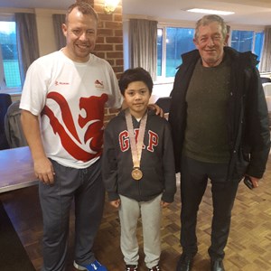 A proud Lewis from a local school, where David presented earlier in the week, coming along to the event at Daventry Bowling Club with his father to try Bowls and get some tips from David