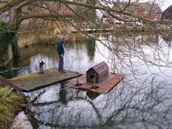 Councillor Clack prepares the duck house for placement in the centre of the pond