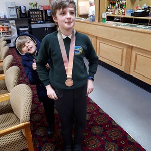 One of the boys team proudly wearing the CWG18 medal with his brother trying to distract him