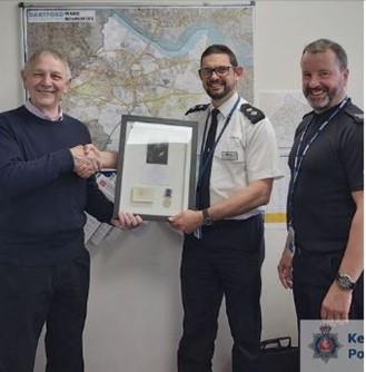 Framed Long Service and Good Conduct Medal being passed by retired police officer Peter Morris to Inspector Trevor Jenner of the Dartford Community Support Unit, Dartford Civic Centre, for display. 12th May 2022