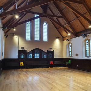 Main hall showing wood floor, arched ceiling with spotlights on ceiling beams