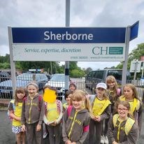 Brownies in a group on a platform at Sherborne train station