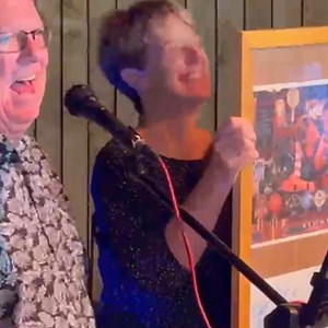 Margo holds up a framed leaving card