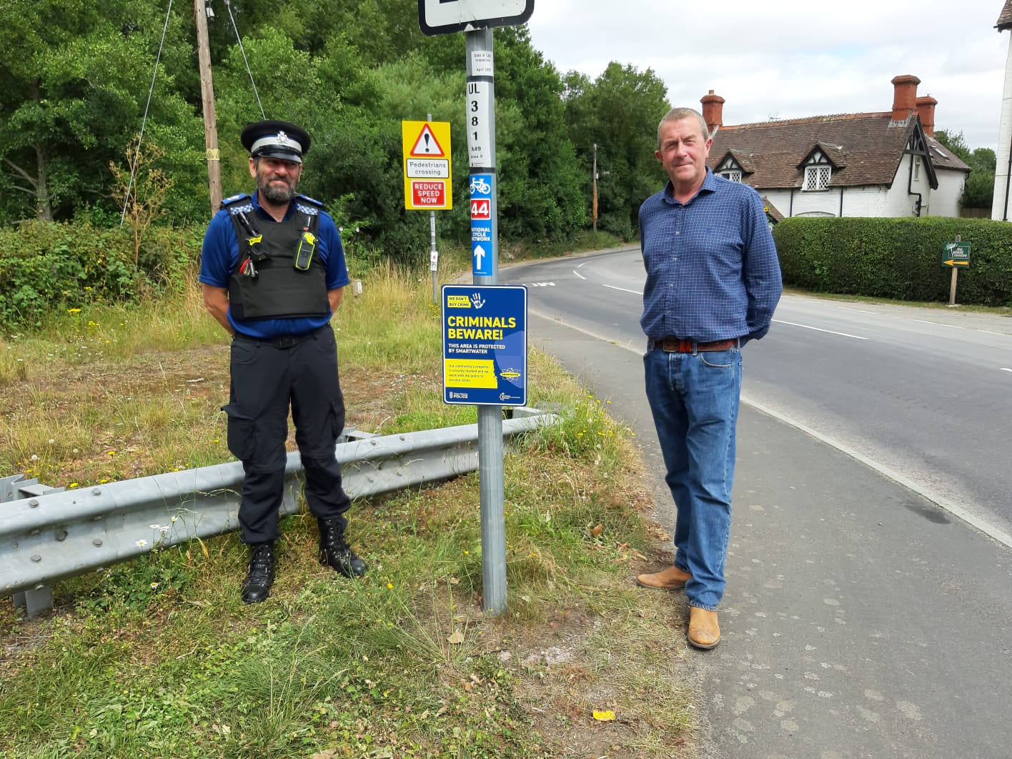 PCSO Dave Baron with PC Clive Leworthy placing Smartwater signs around the Parish to deter criminals.