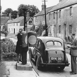 Car being filled with petrol outside the village shop. The only petrol pump between Sydling and Yeovil.