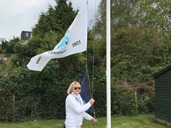 Club President Ann Gibson raises the flag
