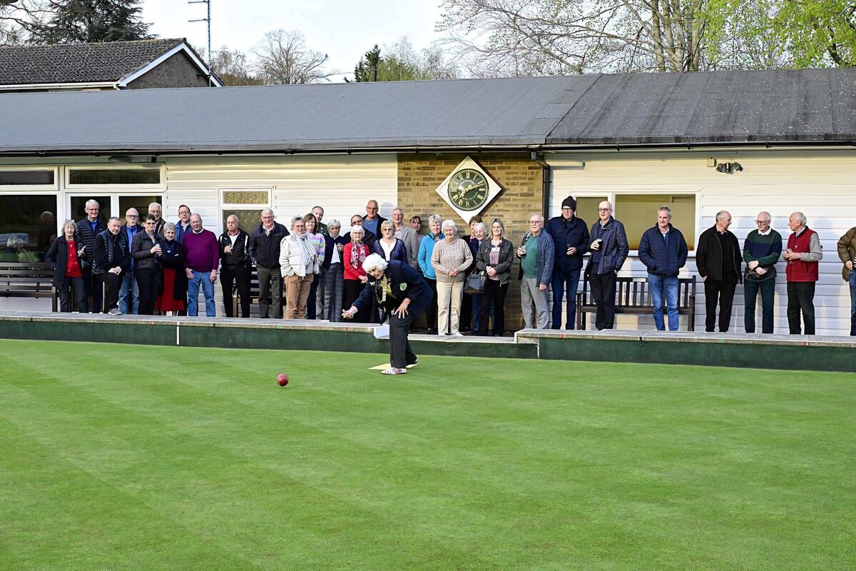 Members watching Sylvia bowling first bowl on the green