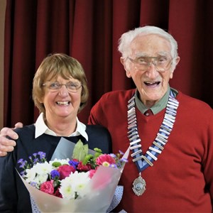President presents secretary with thank-you bouquet from the club.