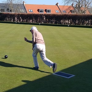 Robin, one of our older members rolling the first wood on opening the green in 2025
