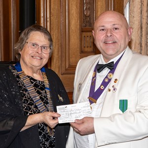 Lion President Janet presenting donation to DG Ian Francis's Partner's charity