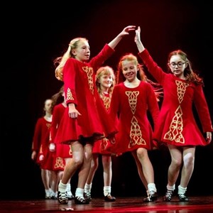 Girls in red dresses dancing at a show