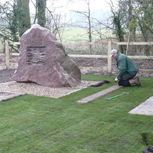 Andy from Acer Landscapes laying the turf at the memorial site. LDC Restoration have started to cut out the stone for insertion of the inscribed granite plaque