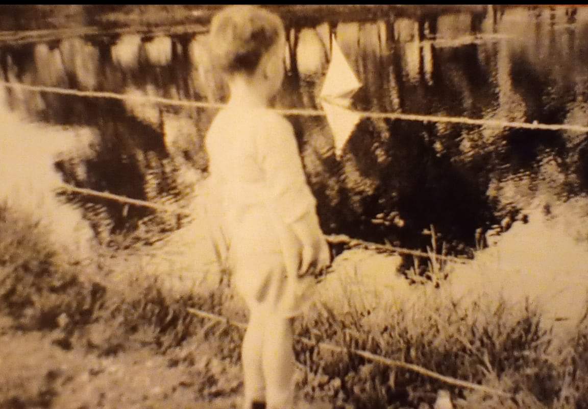 A young Charlie Bateman standing by the pond.