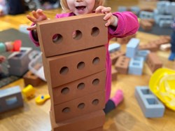 girl building a brick tower