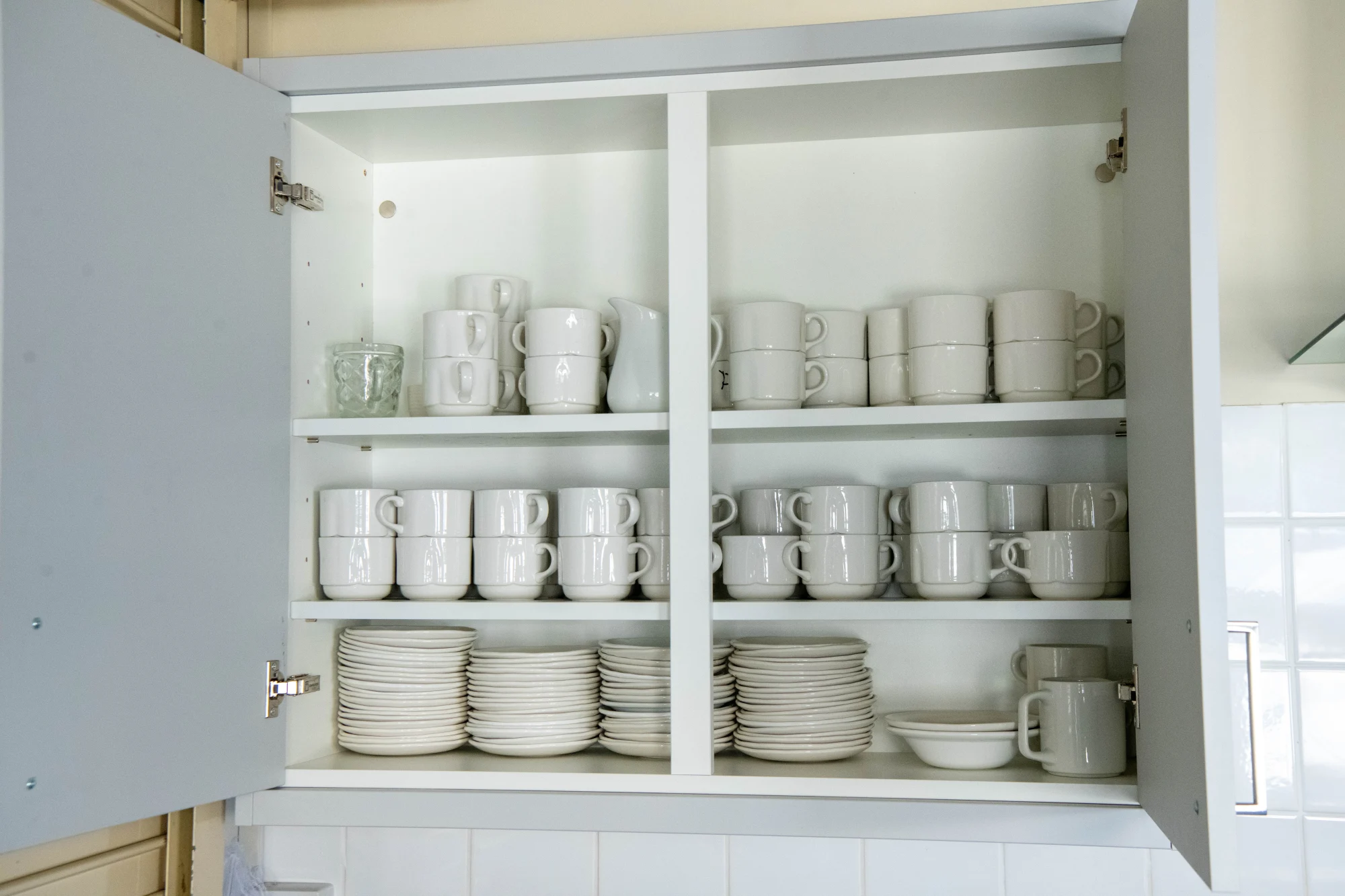 The kitchen is fully stocked with crockery and glasswear