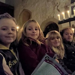 Brownies standing in the candle lit church ready to sing