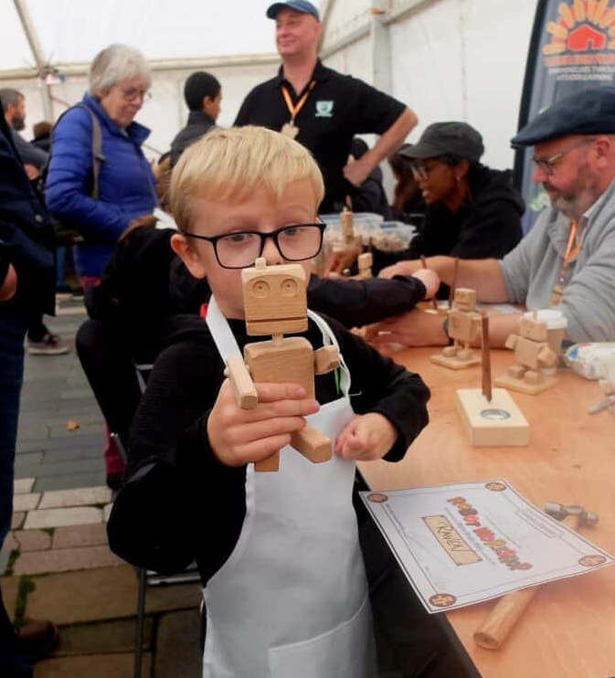 A young maker shows off the robot he made at the Assemble Derby Event