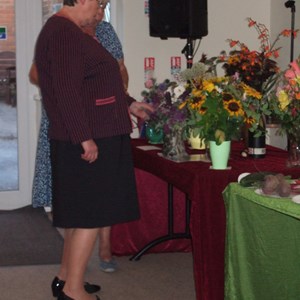 Cllr Sue Saddington judging the best vase of flowers
