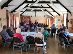 Visitors to Coffee and Chat enjoying a musical presentation by the Purple Group